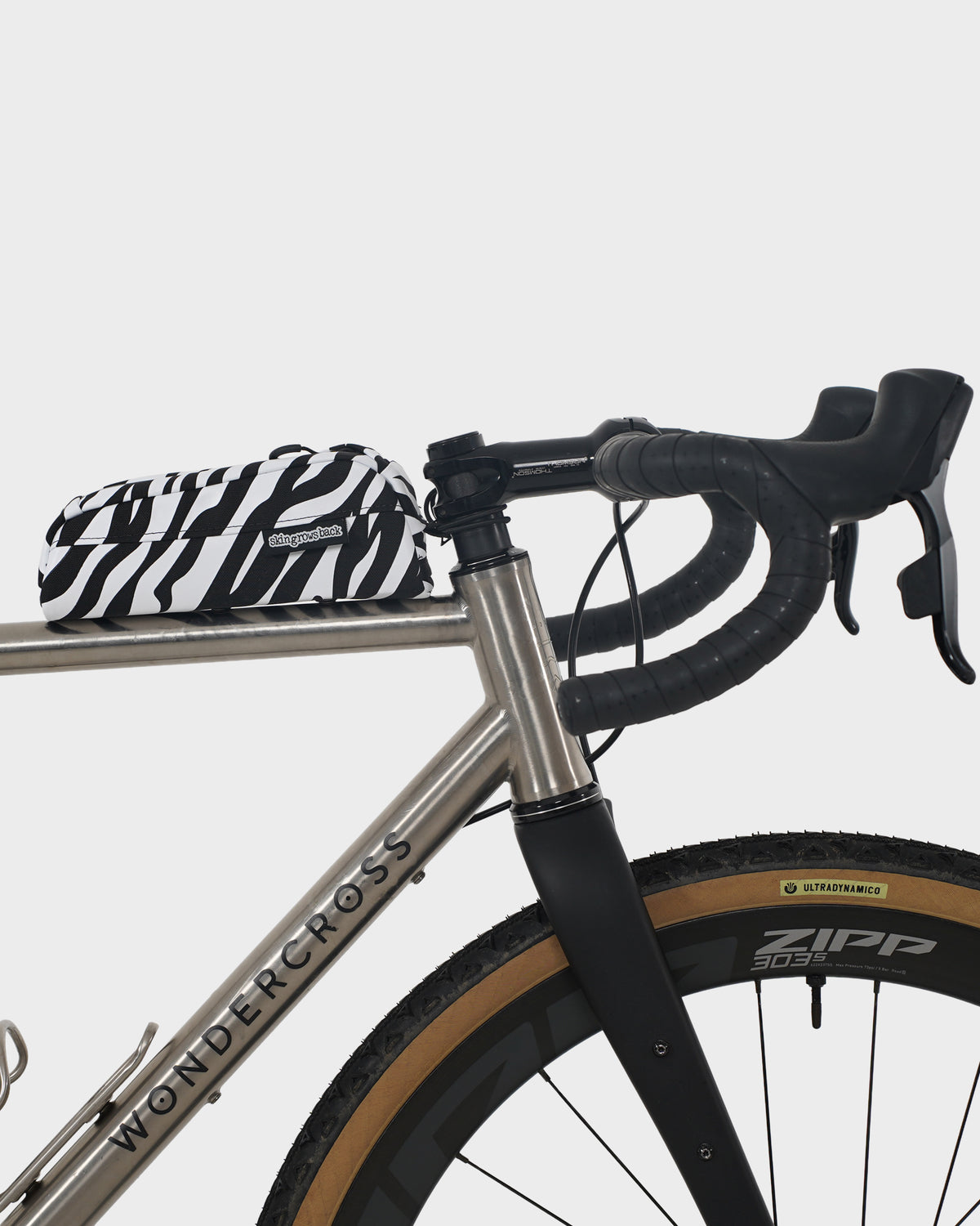 skingrowsback Hot Dog bolt on top tube bag black and white zebra print on a titanium gravel bike with a white background