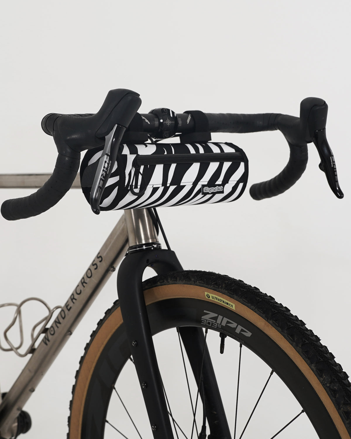 skingrowsback little lunch handlebar bag black and white zebra print on a titanium gravel bike with a white background