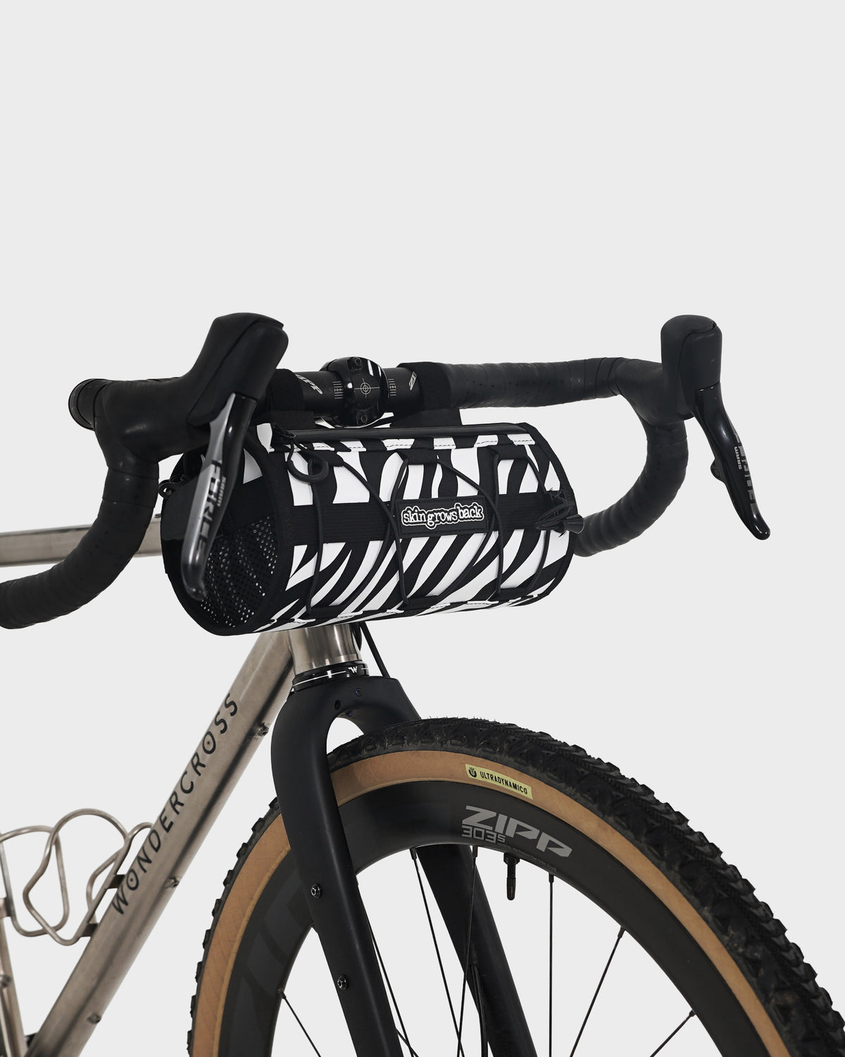 skingrowsback lunchbox handlebar bag black and white zebra print on a titanium gravel bike with a white background