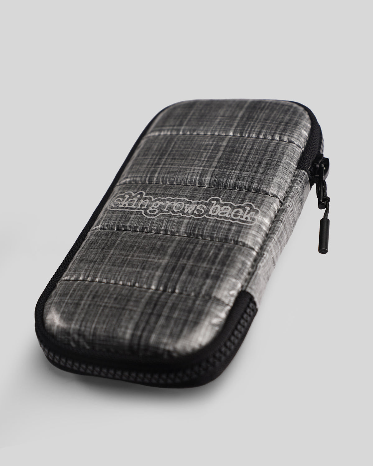skingrowsback phone jacket with dyneema silver zip case with logo on a grey background