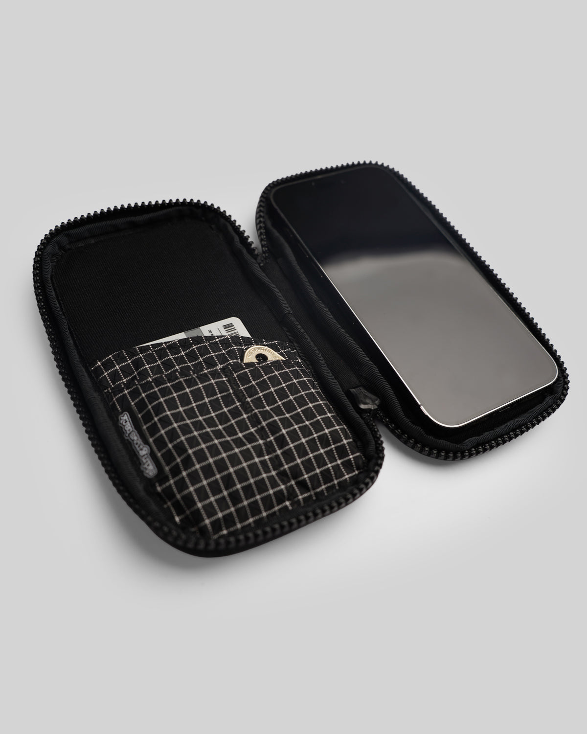 skingrowsback phone jacket with dyneema zip case open with a phone card and key inside on a grey background