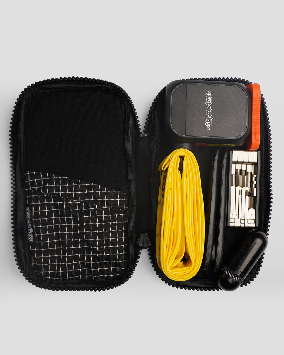 skingrowsback phone jacket with dyneema zip case open with an epump yellow tpu inner tube multi-tool orange button battery holder black tyre levers black plug kit inside on a grey background
