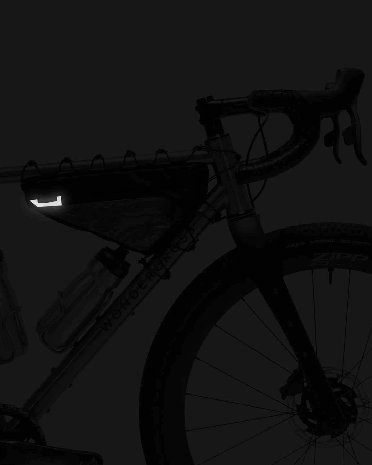 Skingrowsback wedge racing frame bag on a gravel bike showing the reflective panel with a dark background