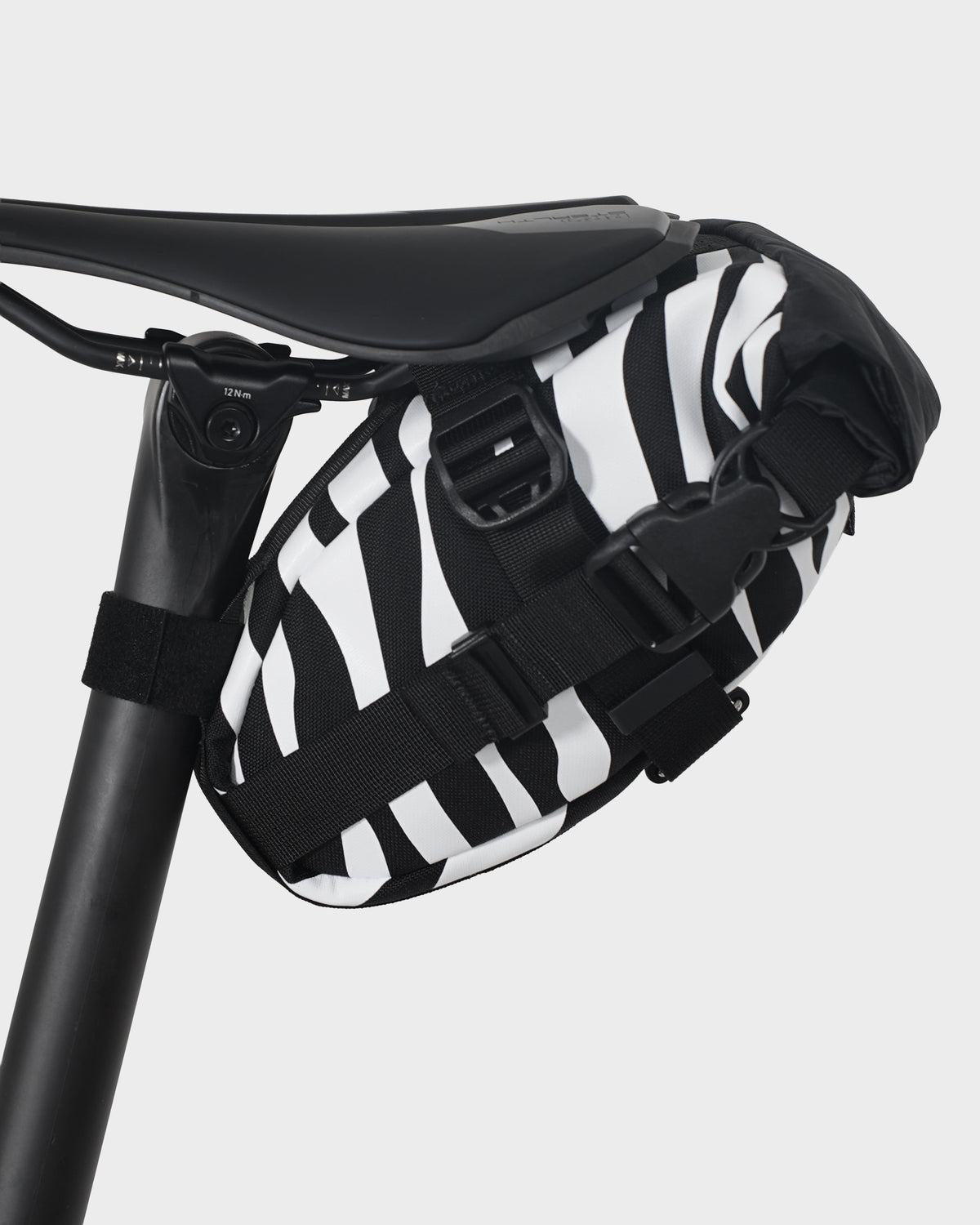skingrowsback flash pak saddle bag black and white zebra print on a black bike saddle with a white background