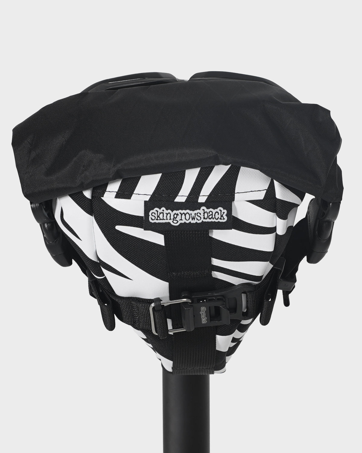 skingrowsback flash pak saddle bag black and white zebra print on a black bike saddle with a white background