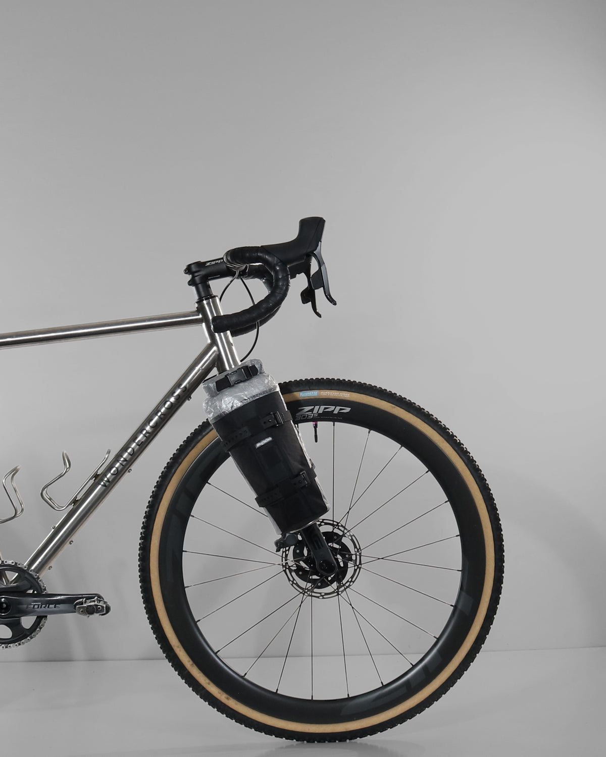 Skingrowsback transcend racing series moai bikepacking fork bag black xpac vx21 with silver dyneema on a titanium gravel bike against a grey background