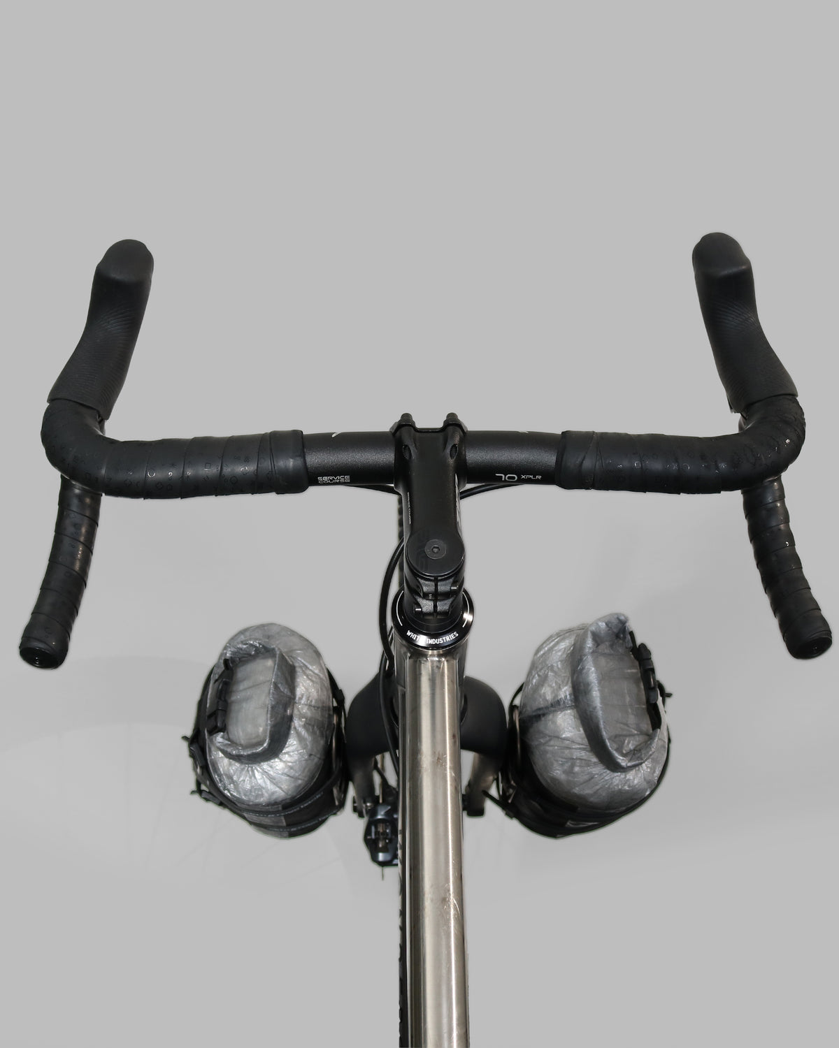 Skingrowsback transcend racing series moai bikepacking fork bag black xpac vx21 with silver dyneema on a titanium gravel bike close up against a grey background