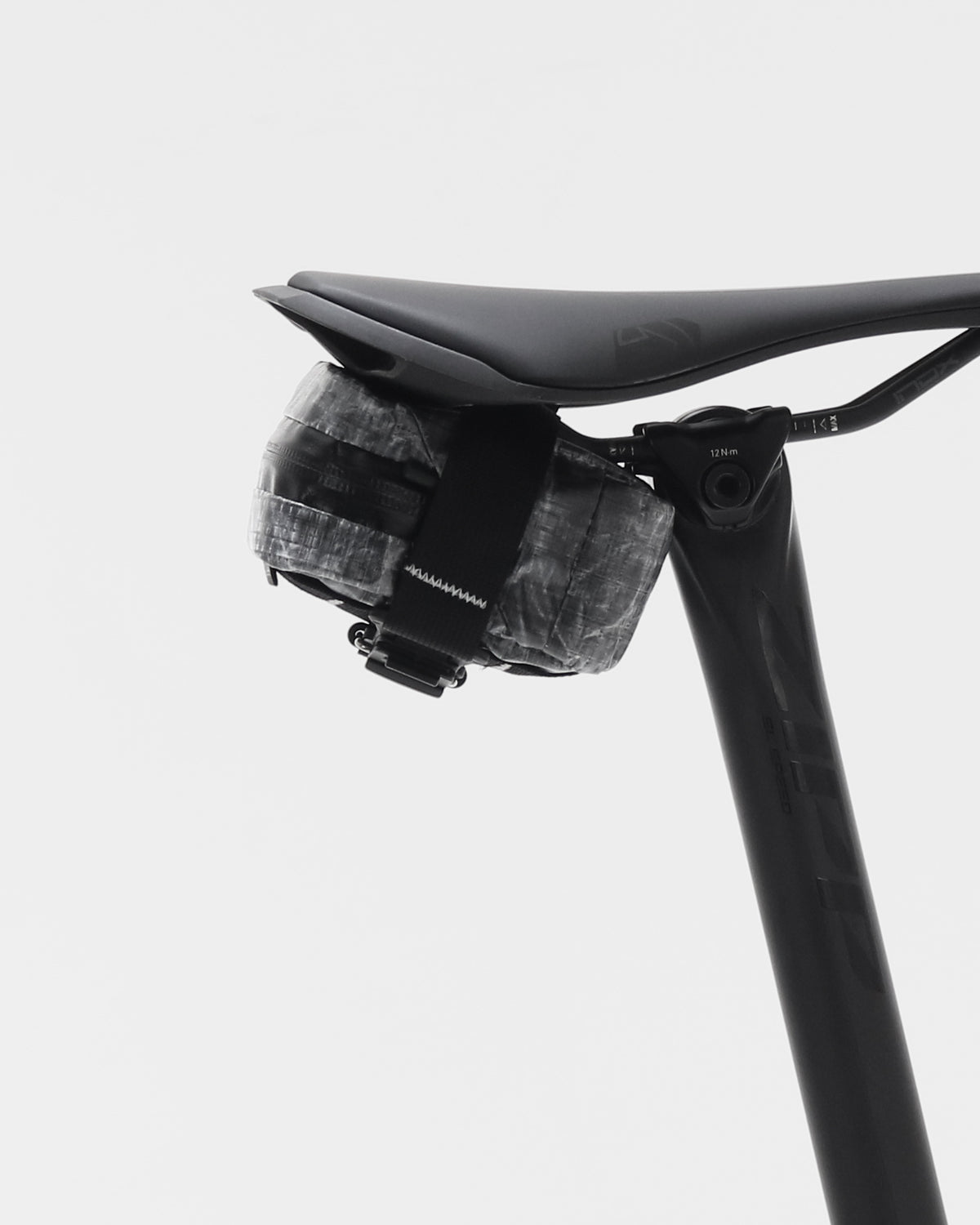 skingrowsback plan b micron saddle bag dyneema black on a black bicycle seat and seatpost against a white background