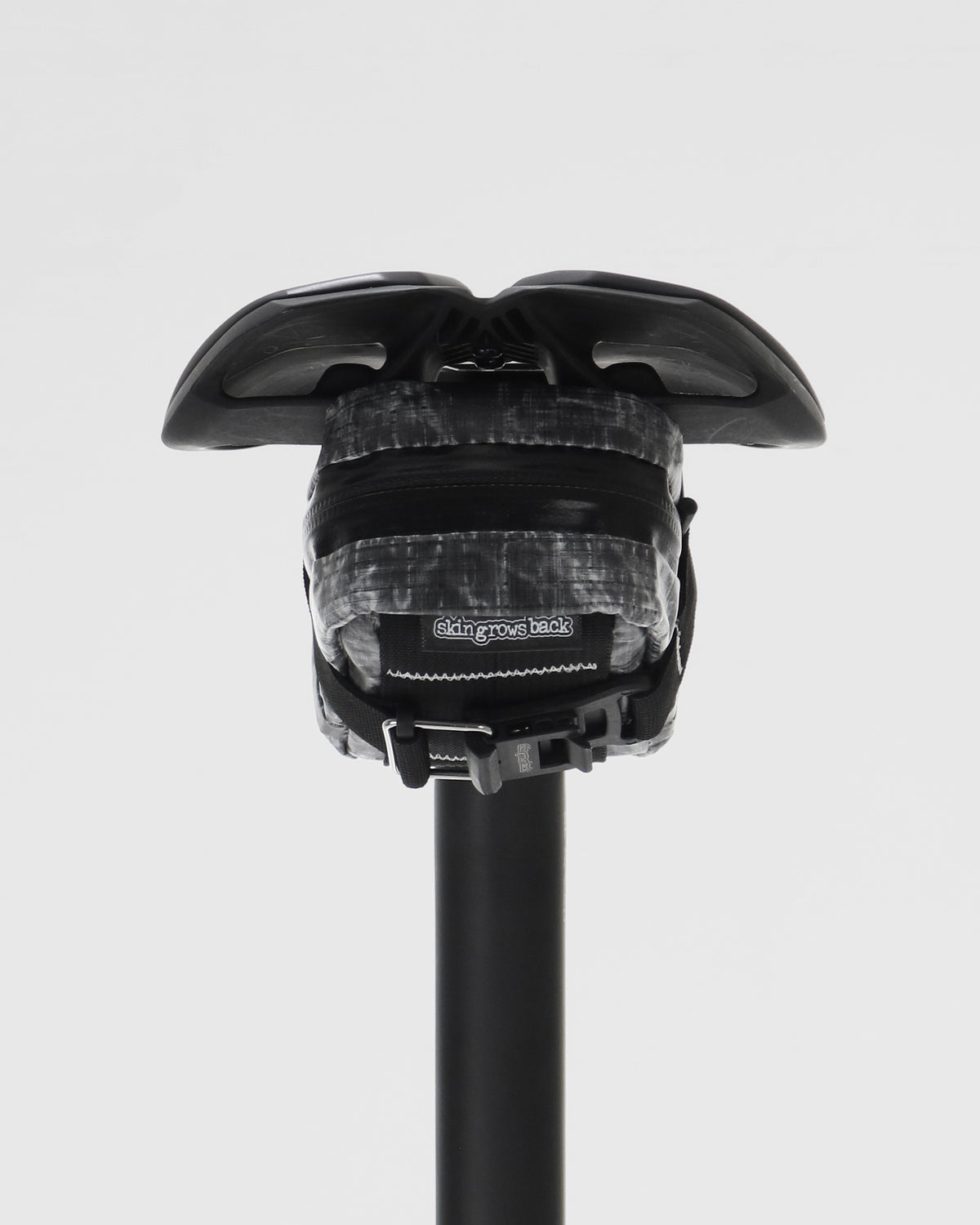 skingrowsback plan b micron saddle bag dyneema black on a black bicycle seat and seatpost against a white background