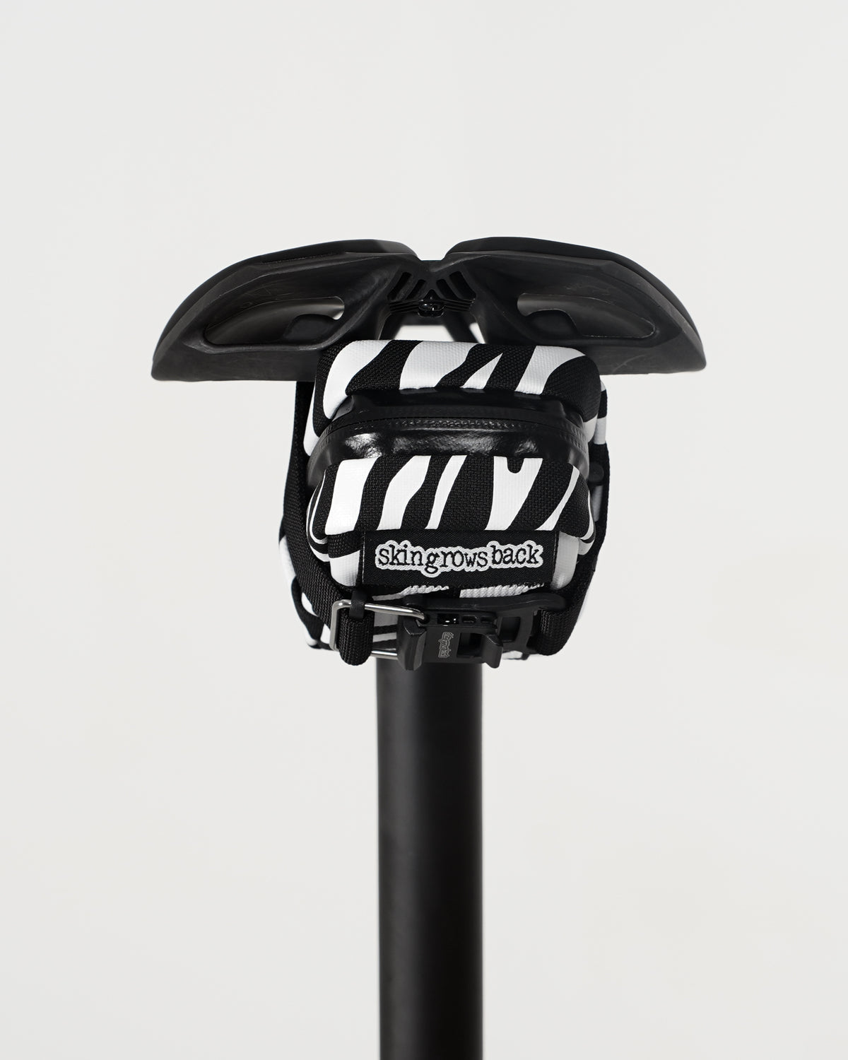 skingrowsback plan b micron saddle bag black and white zebra print on black saddle with a white background