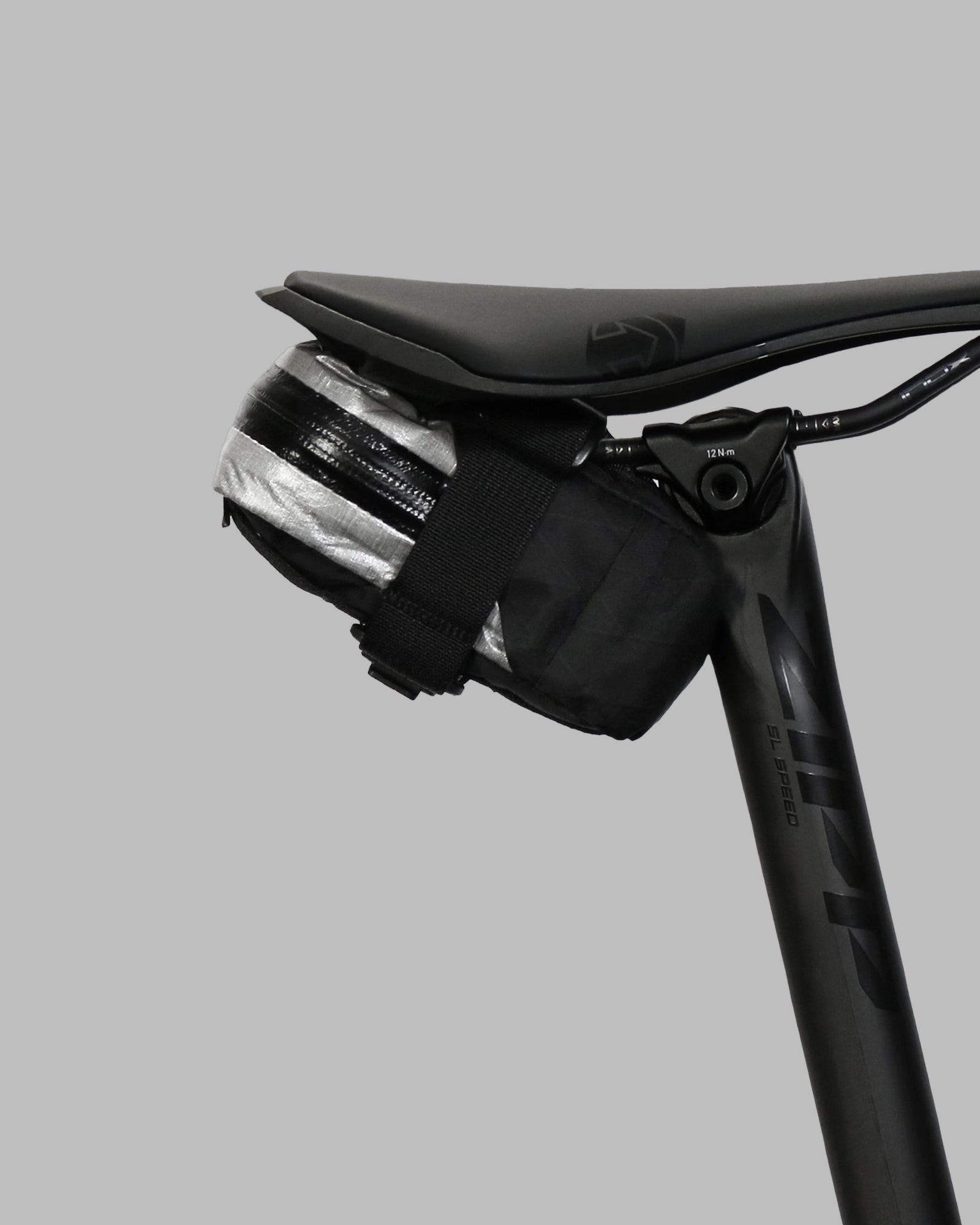 Skingrowsback plan b micron racing saddle bag black xpac vx21 plus reflective dyneema on a black bike seat