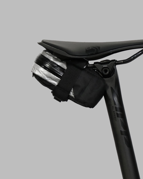 Skingrowsback plan b micron racing saddle bag black xpac vx21 plus reflective dyneema on a black bike seat