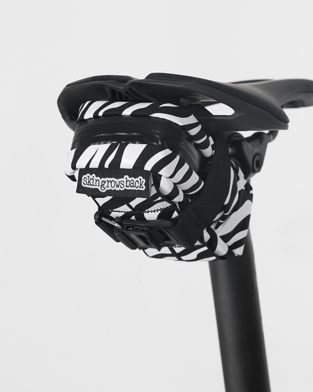 skingrowsback plan b saddle bag black and white zebra print on black saddle with a white background