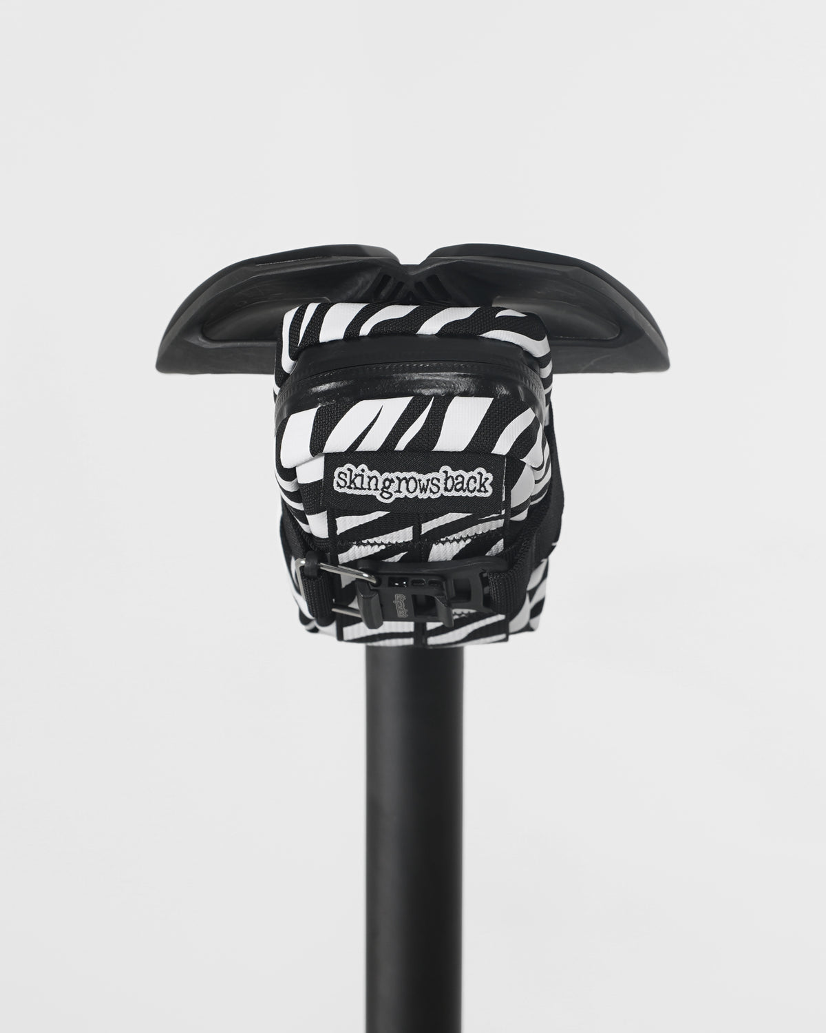 skingrowsback plan b saddle bag black and white zebra print on black saddle with a white background