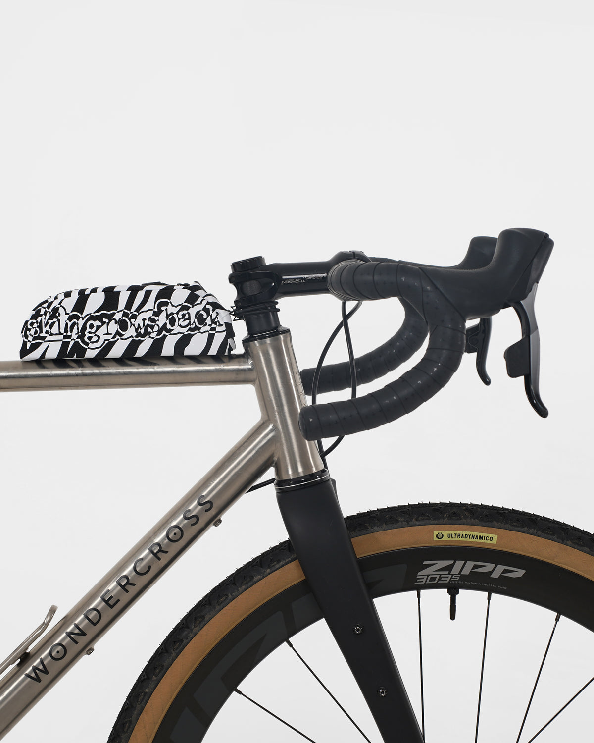 skingrowsback shortie top tube bag black and white zebra print on a titanium gravel bike with a white background