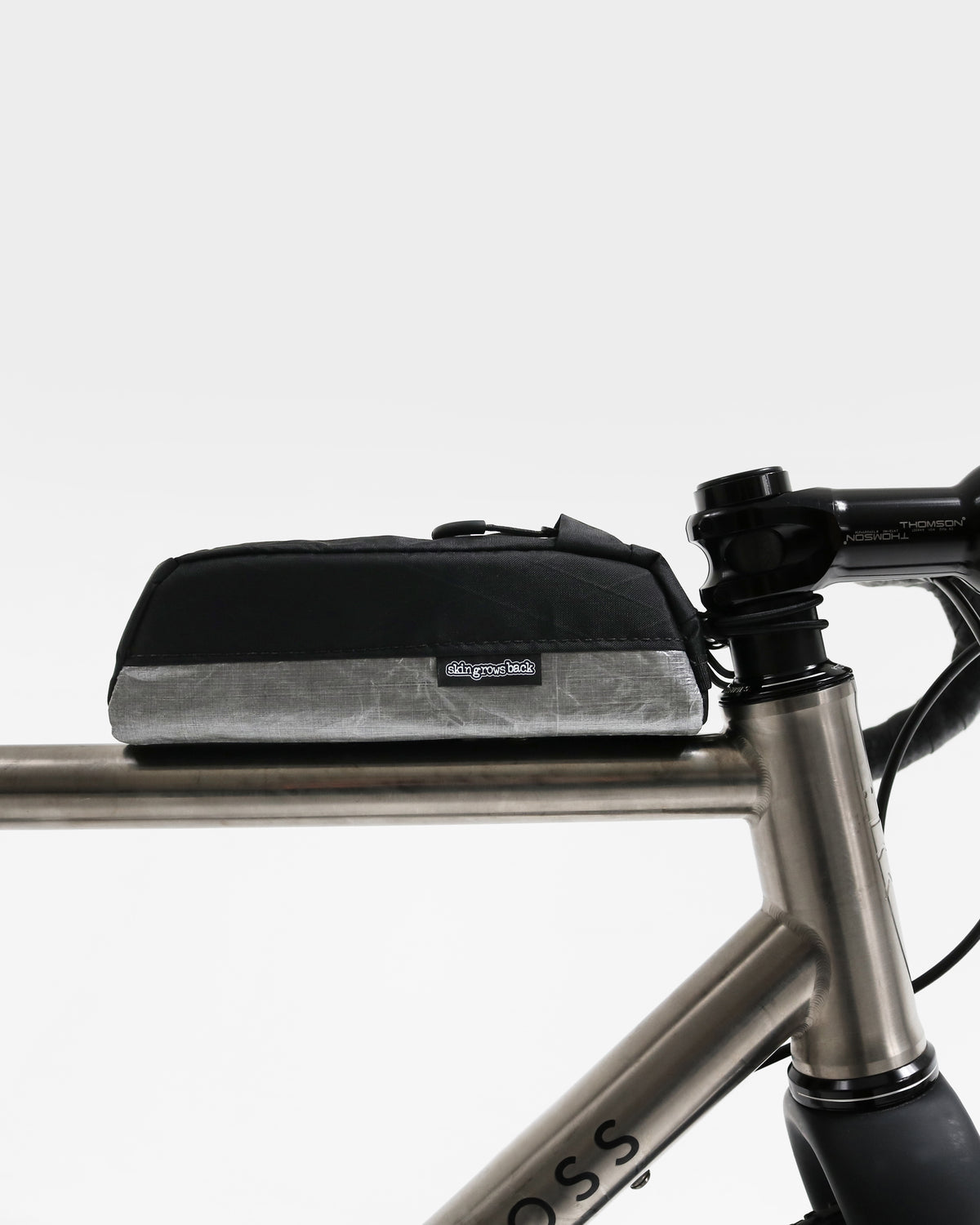 Skingrowsback Shortie Racing top tube bag bolt on black xpac vx21 silver dyneema on a titanium gravel bike on a white background