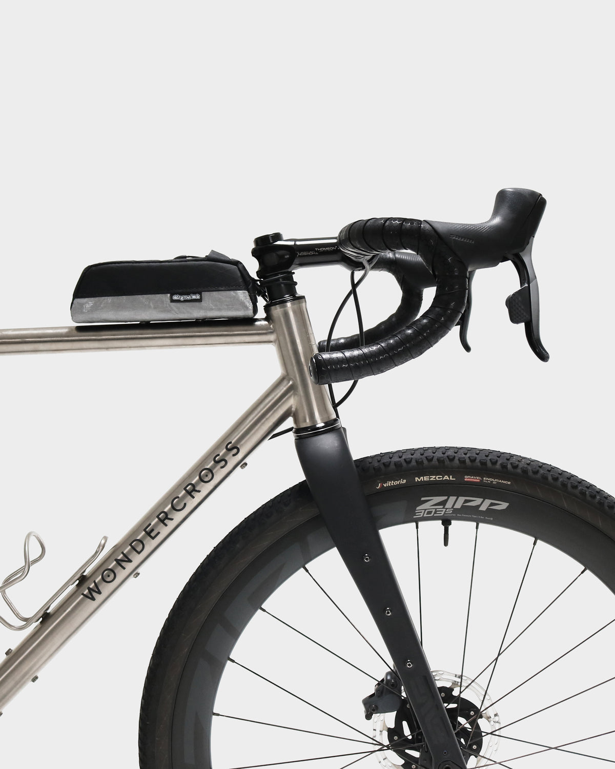 Skingrowsback Shortie Racing top tube bag bolt on black xpac vx21 silver dyneema on a titanium gravel bike on a white background