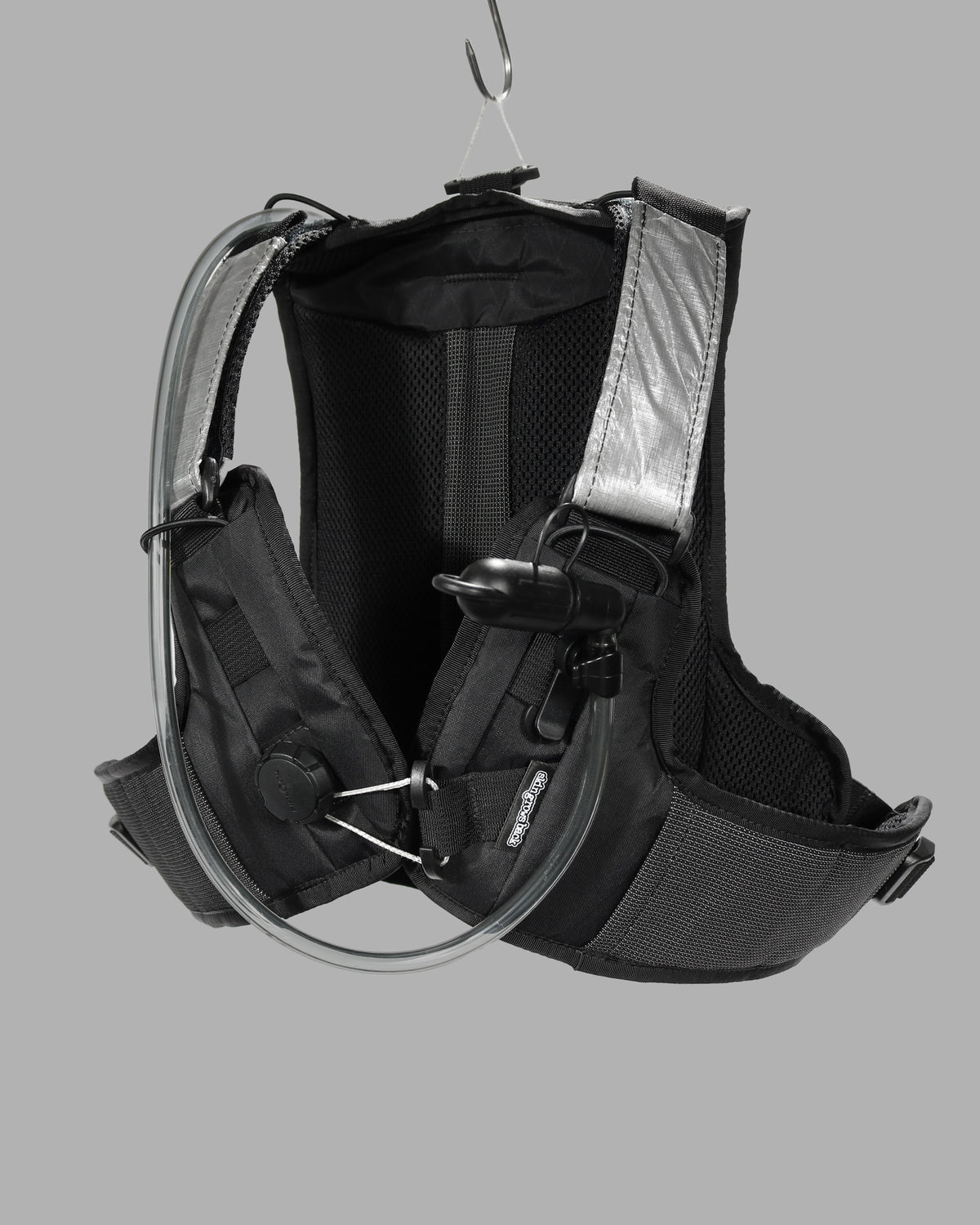 Skingrowsback transcend racing series transition 1.5 litre hydration backpack black and silver against a grey background